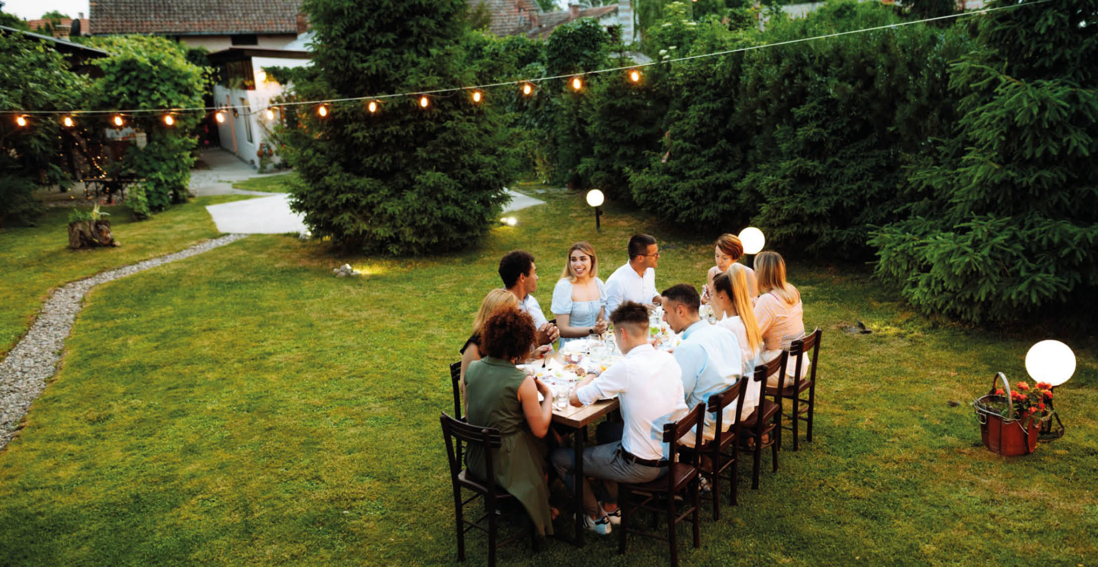 Group of diverse people enjoying summer afternoon and evening in garden party