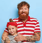 Family portrait of handsome older brother embraces little sister, love each other, look alike, dressed casually, isolated on blue background, copy space for your promotion. Children, relatives concept